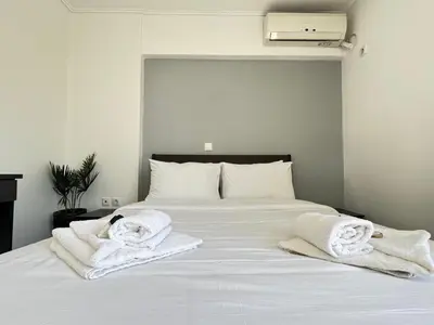 a white bed with towels on top of it at 6th Floor Serenity Apartment in Zografou, Athens in Athens