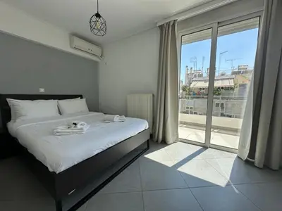 a bedroom with a bed and a large window at 6th Floor Serenity Apartment in Zografou, Athens in Athens