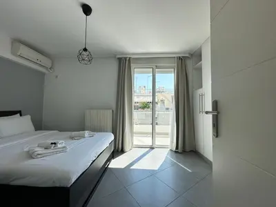 a bedroom with a bed and a large window at 6th Floor Serenity Apartment in Zografou, Athens in Athens