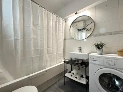 a bathroom with a washing machine and a mirror at 6th Floor Serenity Apartment in Zografou, Athens in Athens