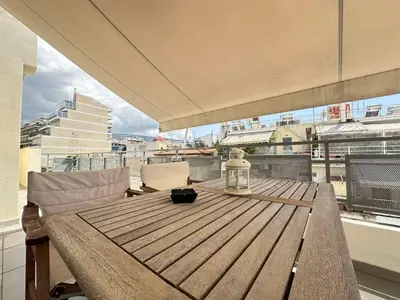 a table on a balcony with a view of a city at 6th Floor Serenity Apartment in Zografou, Athens in Athens