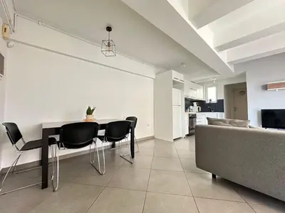 a dining room with a table and chairs and a couch at 6th Floor Serenity Apartment in Zografou, Athens in Athens