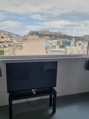 a flat screen tv sitting in front of a window at athens parthenon view in Athens