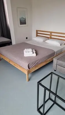 a bed with a wooden frame and a glass table at athens parthenon view in Athens