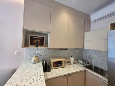 a kitchen with white cabinets and a microwave on a counter at Syntagma Elegance on Ermou in Athens