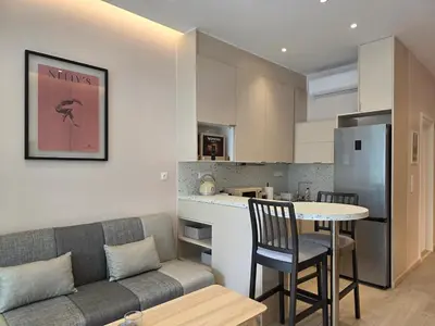 a living room with a couch and a table and a kitchen at Syntagma Elegance on Ermou in Athens
