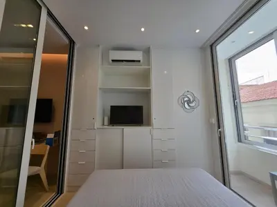 a bedroom with a bed and a tv and a window at Syntagma Elegance on Ermou in Athens