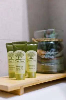 three bottles of olive tree products on a shelf at Cozy 2 Bedroom Apartment Gaia by Philoxenia in Athens