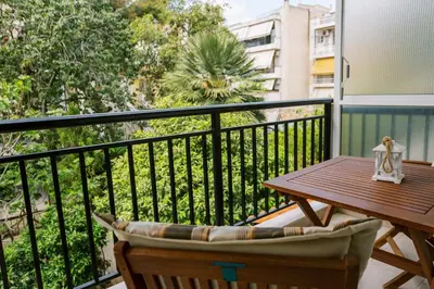 a balcony with a wooden table and chair and a table at Cozy 2 Bedroom Apartment Gaia by Philoxenia in Athens
