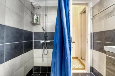 a shower with a blue curtain in a bathroom at Acropolis Vintage Apartment in Athens