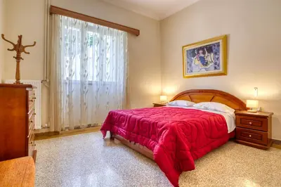 a bedroom with a red bed and a window at Acropolis Vintage Apartment in Athens