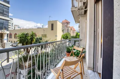 a balcony with two chairs and a view of a city at Acropolis Vintage Apartment in Athens