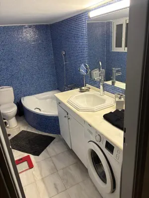 a bathroom with a sink and a washing machine at Sunlit Panorama Faliro in Athens