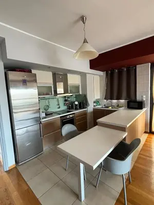 a kitchen with a table and a refrigerator at Sunlit Panorama Faliro in Athens