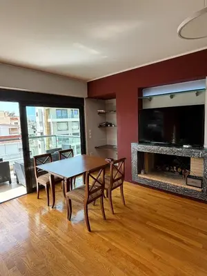 a dining room with a table and a fireplace at Sunlit Panorama Faliro in Athens
