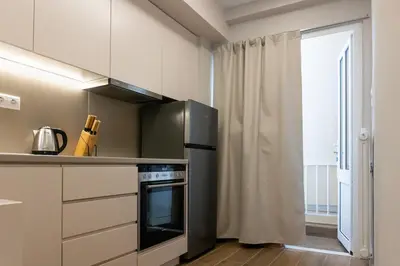 a kitchen with a black refrigerator and a window at Elegant Suite - Piraeus in Piraeus