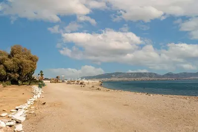 a beach with a dirt road and the water at Elegant Suite - Piraeus in Piraeus