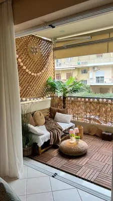 a patio with a couch and a table on a balcony at Boubous house in Athens