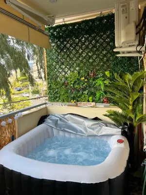 a jacuzzi tub in front of a green wall at Boubous house in Athens