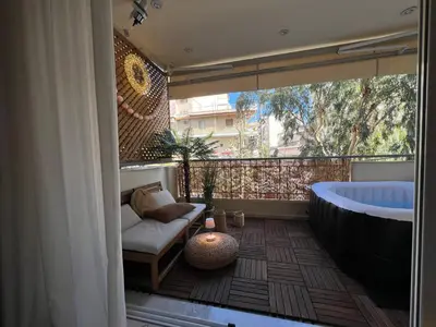 a bathroom with a tub and a couch and a chair at Boubous house in Athens