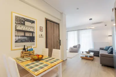 a kitchen and living room with a table and a couch at Bright 2 Bedroom Apartment Helios by Philoxenia in Athens