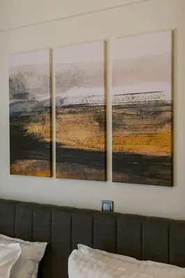 three paintings hanging on a wall above a couch at Bright 2 Bedroom Apartment Helios by Philoxenia in Athens