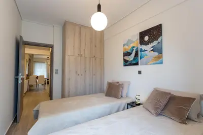 a bedroom with two beds and a closet at Bright 2 Bedroom Apartment Helios by Philoxenia in Athens