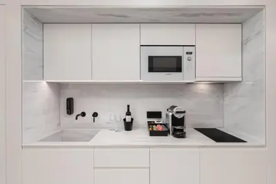 a kitchen with white cabinets and a microwave at capital house in Athens
