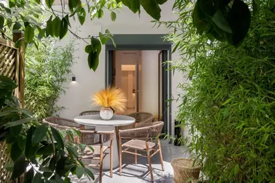 a patio with a table and chairs and plants at capital house in Athens