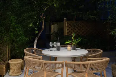 a white table with three chairs and a bottle of wine at capital house in Athens