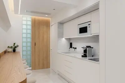 a kitchen with white cabinets and a microwave at capital house in Athens