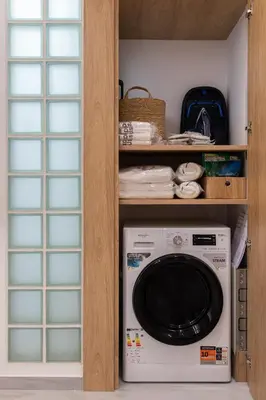 a laundry room with a washing machine in a cabinet at capital house in Athens