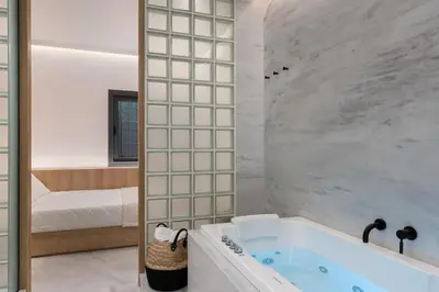 a bathroom with a bath tub and a bedroom at capital house in Athens
