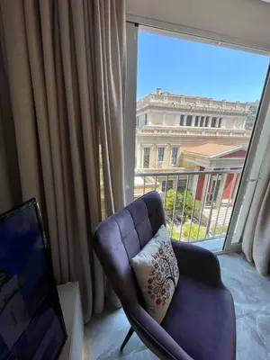 a purple chair in a room with a large window at Athens Central Studios 2 in Athens