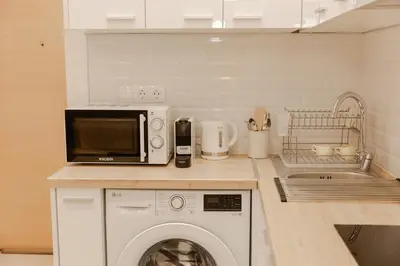 a kitchen with a washing machine and a microwave at Luxury&Zen DownTown Apartment by MPS in Athens