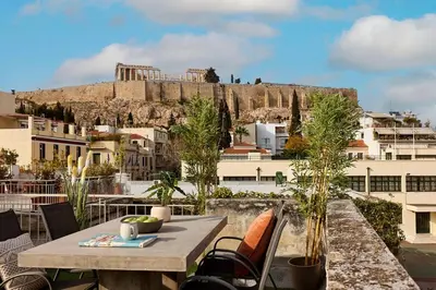 a table and chairs with a view of the acropolis at Acropolis Delight Residence II in Athens