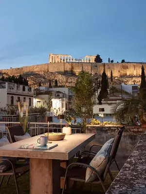 a table and chairs with a view of the acropolis at Acropolis Delight Residence II in Athens