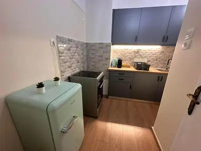 a small kitchen with a refrigerator and a stove at Check Point - Acropolis Shadow in Athens