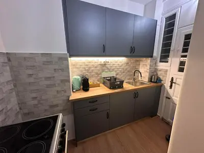 a small kitchen with blue cabinets and a sink at Check Point - Acropolis Shadow in Athens
