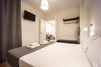 a bedroom with a white bed with towels on it at Galini Acropolis Lux Apartment in Athens