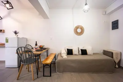 a room with a bed and a table and a kitchen at Galini Acropolis Lux Apartment in Athens