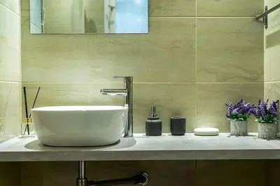 a bathroom with a bowl sink on a counter at Galini Acropolis Lux Apartment in Athens