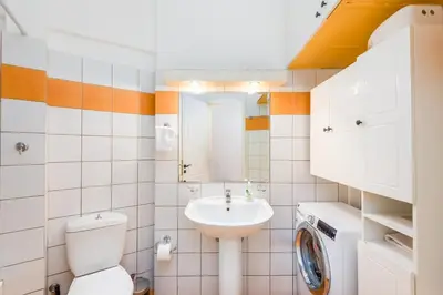 a bathroom with a toilet sink and a washing machine at Cozy appartment in Neo Faliro, Piraeus in Piraeus