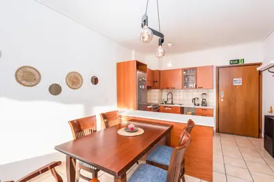 a kitchen and dining room with a wooden table and chairs at Cozy appartment in Neo Faliro, Piraeus in Piraeus