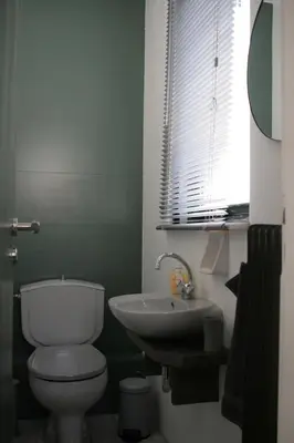a bathroom with a toilet and a sink and a window at SunLoft35 by MPS in Athens