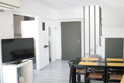 a living room with a tv and a table with chairs at SunLoft35 by MPS in Athens