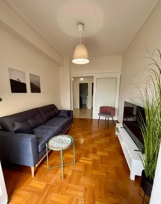 a living room with a couch and a table at At Polyla Everything close,nothing loud in Athens