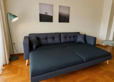 a couch in a living room with two pictures on the wall at At Polyla Everything close,nothing loud in Athens