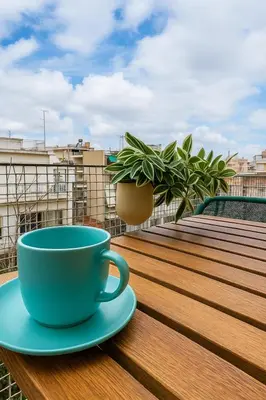 a blue coffee cup sitting on a table on a balcony at At Polyla Everything close,nothing loud in Athens