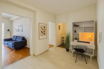 a living room with a blue couch and a desk at At Polyla Everything close,nothing loud in Athens